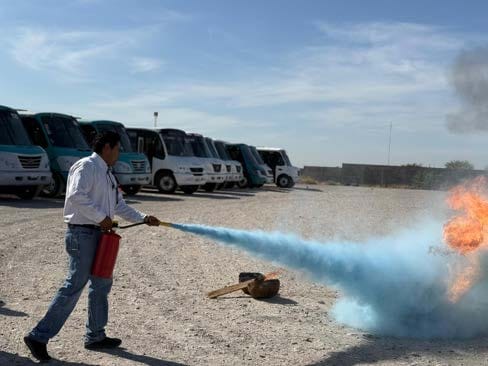 Instructor de Punto Transportes enseñando a usar un extintor en una práctica de incendios