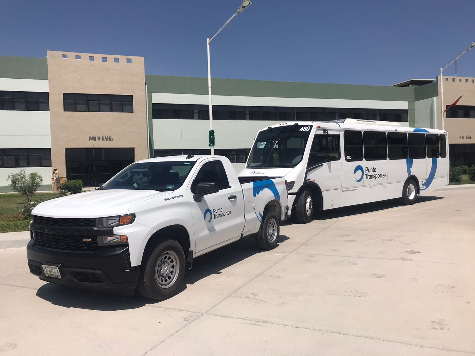 Camioneta y autobús de Punto Transportes frente a una planta